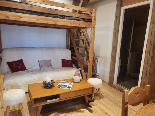 a bedroom with a bunk bed and a table at Le Nid des Cerfs in Essert La Pierre