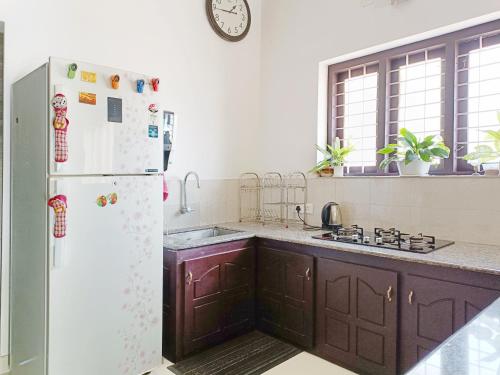 a kitchen with a refrigerator and a sink at Alma Homestay in Mararikulam