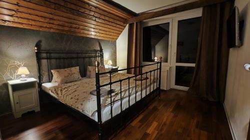 Schlafzimmer mit einem schwarzen Bett und einer Holzdecke in der Unterkunft Chata pod Pustevnami in Prostřední Bečva