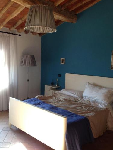 1 dormitorio con 1 cama con pared azul en Regina Rooms Pisa, en Pisa