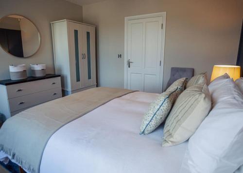 a bedroom with a large white bed with pillows at Rockfield in Kinvara