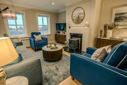 a living room with blue furniture and a fireplace at Rockfield in Kinvara