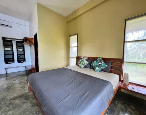 1 dormitorio con 1 cama grande y 2 ventanas en Siargao Wakepark en General Luna
