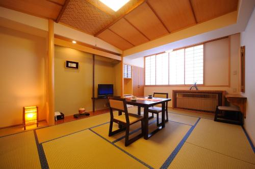a dining room with a table and a window at Suzukiya Ryokan in Shiroishi