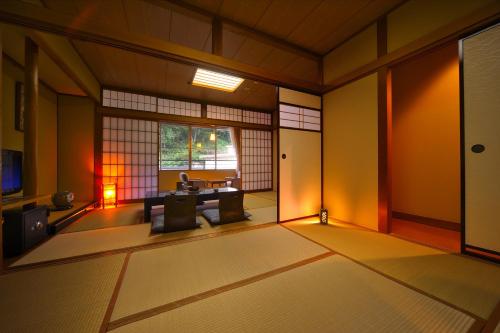 a japanese room with a table and a window at Suzukiya Ryokan in Shiroishi