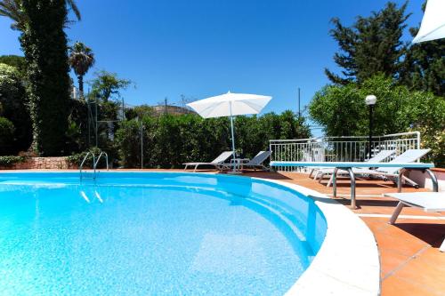 a swimming pool with two chairs and an umbrella at Villa Nice Dream With Pool And Terrace - Happy Rentals in Neviano