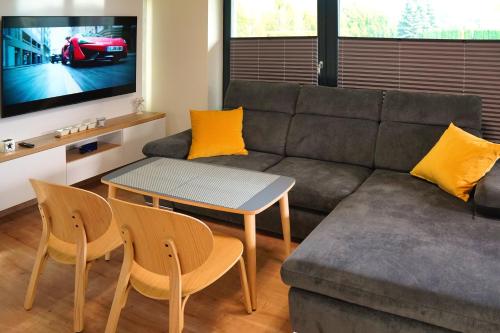 a living room with a couch and a table and yellow pillows at Ubytování v Beskydech - Apartmán Kája in Čeladná