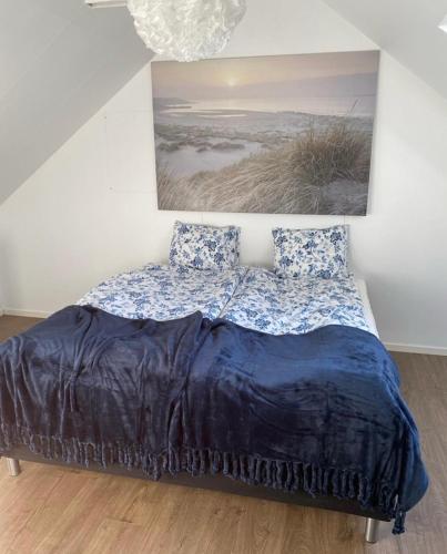un letto con piumone blu in una camera da letto di Kungs Bäcks Gård Höllviken a Höllviken