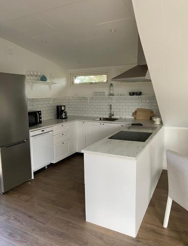 a kitchen with white cabinets and a counter top at Kungs Bäcks Gård Höllviken in Höllviken