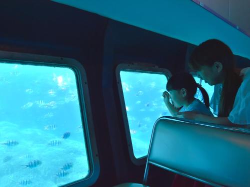 a woman and a child looking at fish in an aquarium at Hotel Shigira Mirage Beach Front in Miyako Island