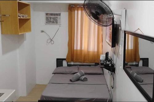 a small room with a bed and a fan at Doc's Place 2 @MPlace with Wi-fi in Manila