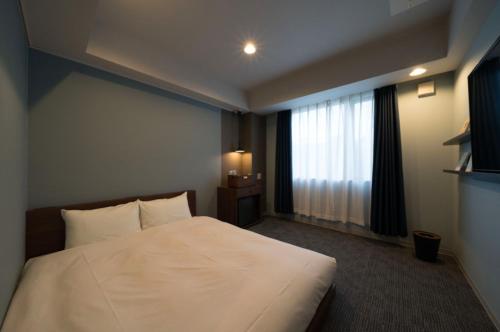 Postel nebo postele na pokoji v ubytování BOOK HOTEL 京都九条