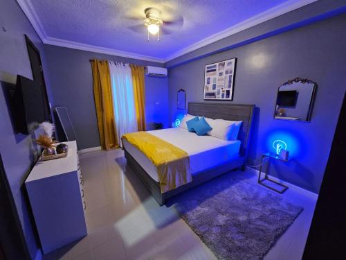 a bedroom with a bed with blue lights on it at Paradise Haven at Hamptons - -across from Ac Marriot Hotel in Kingston