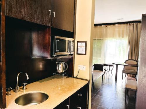 a kitchen with a sink and a microwave at Mafumu Hotel in Lilongwe