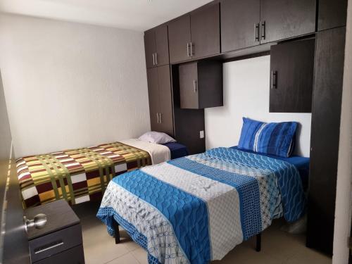 Habitación pequeña con 2 camas y armarios en Habitacion Lomas de San Pedro, en Carrillo
