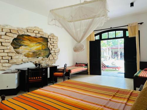 una camera da letto con parete in pietra, tavolo e scrivania di Traum Villa a Bentota