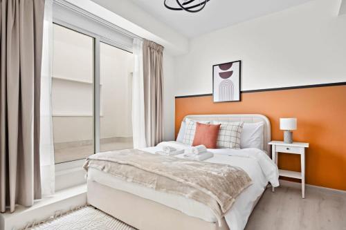 a bedroom with a bed with an orange wall at Silkhaus Modern 1BDR in DIFC near Metro Station in Dubai
