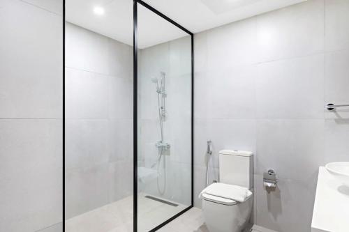 a white bathroom with a shower and a toilet at Silkhaus High Floor in Millennium Executive Tower in Dubai
