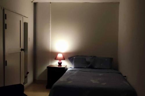 チクラーヨにあるAcogedora habitación privada en Chiclayo.のベッドルーム1室(ナイトスタンドにランプ付)