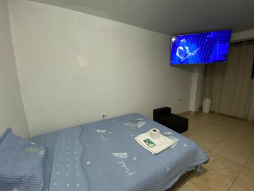 a bedroom with a bed with a tv on the wall at Acogedora habitación privada en Chiclayo. in Chiclayo