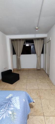 a living room with a bed and a couch at Acogedora habitación privada en Chiclayo. in Chiclayo