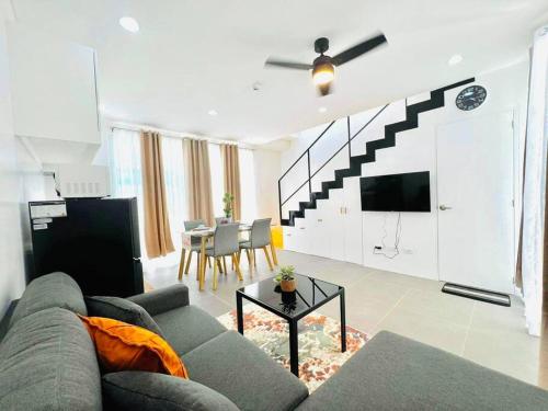ein Wohnzimmer mit einem Sofa und einem Esszimmer in der Unterkunft Artscapes by Kavanah Suites in Batangas City
