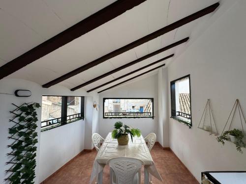 - une salle à manger avec une table, des chaises et des fenêtres dans l'établissement Casa Rural El Alcázar - Cehegín, à Cehegín