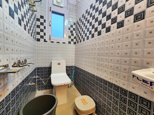 a bathroom with a black and white tiled wall at Mountain Mist Shimla in Shimla