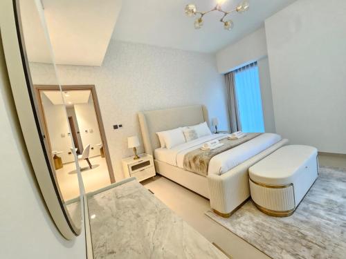 a white bedroom with a bed and a mirror at Brand New Luxurious 2BR ACT Towers Downtown in Dubai