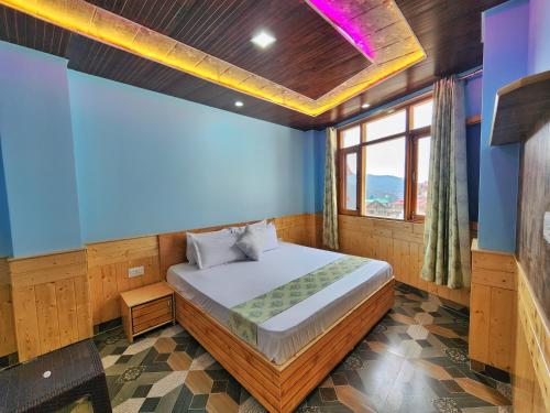 a bedroom with a bed and a blue wall at Mountain Mist Shimla in Shimla