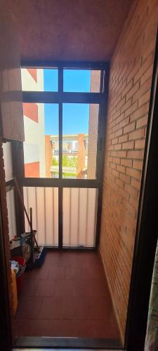 a hallway with a large window in a brick wall at Apartamento Bulevar in Burgos
