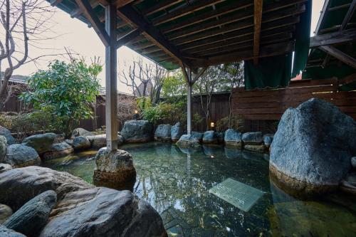 a pool of water with rocks in a garden at Royal Hotel Kawaguchiko in Fujikawaguchiko