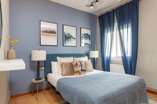 Schlafzimmer mit blauen Wänden und einem Bett mit Kissen in der Unterkunft City View Penthouse - 2 Bedroom Suite in Barcelona