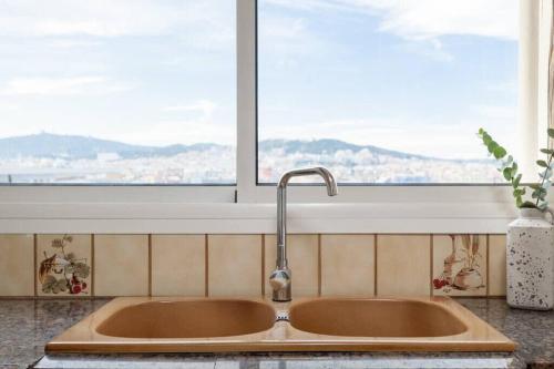 ein Waschbecken in einer Küche mit Fenster in der Unterkunft City View Penthouse - 2 Bedroom Suite in Barcelona