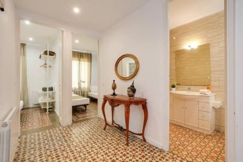 a bathroom with a table and a sink and a mirror at Sagrada Familia- Emblematic and Charming Catalan Home in Barcelona