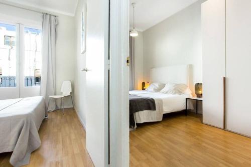 een slaapkamer met een bed en een bureau in een kamer bij Bright and modern 3bedroom in Las Ramblas 3 1B in Barcelona