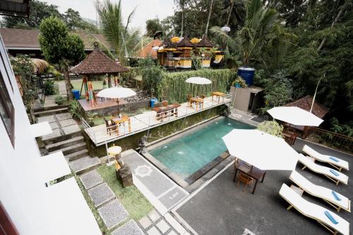 an overhead view of a swimming pool with tables and umbrellas at Astana Swaha Villa in Sidemen