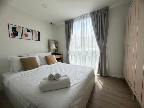 - une chambre avec un lit et 2 serviettes dans l'établissement chateau in-town ratchayothin BTS, à Ban Yang