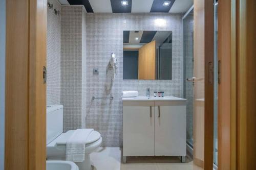 a bathroom with a toilet and a sink and a mirror at Modern and bright apartment in Eixample 5-2 in Barcelona