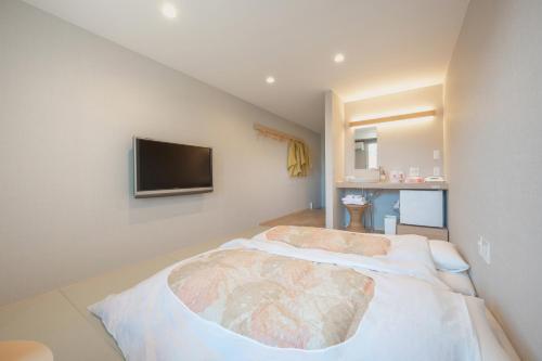 a bedroom with a bed with a tv on the wall at Royal Hotel Kawaguchiko in Fujikawaguchiko