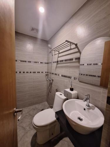 a bathroom with a toilet and a sink at Casa Ison Hotel in Sablayan