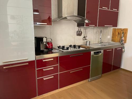 a kitchen with red cabinets and a stove top oven at La Pulchella in LʼAquila