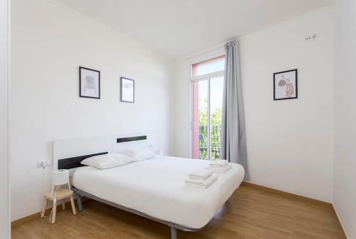 Habitación blanca con cama y ventana en Sunny 3BD apartment in Poblenou next to the beach, en Barcelona