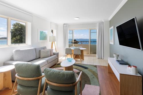 Una sala de estar con un sofá y un televisor. en Ramada Resort by Wyndham Shoal Bay, en Shoal Bay