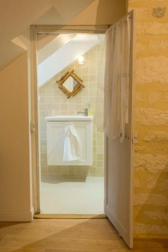 a bathroom with a sink and a white towel at La Maison du Haut in Tonnerre