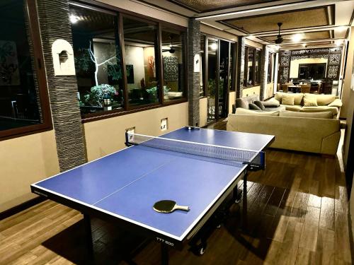 a ping pong table with a racket in a room at Uluwatu Huge 6 Bed Spa Villa - G8 views & Child Friendly in Jimbaran