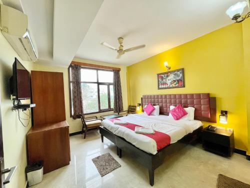 a bedroom with a large bed with pink pillows at Hotel Surya Beach inn ! PURI near-sea-beach-and-temple fully-air-conditioned-hotel with-lift-and-parking-facility in Puri