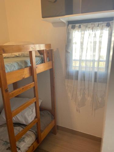 - un lit superposé avec une échelle dans une chambre avec une fenêtre dans l'établissement Studio cabine moderne - parking & terrasse, à La Grande Motte