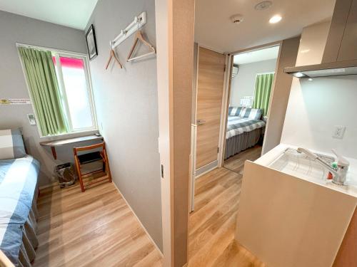 een kleine kamer met een bed en een badkamer bij SHINJUKU WARM HOUSE in Tokyo