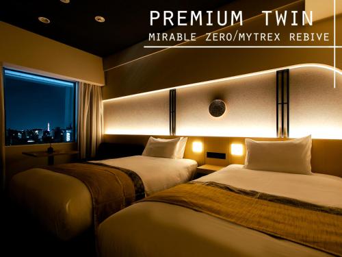 two beds in a hotel room with a window at Hotel Gracery Kyoto Sanjo in Kyoto